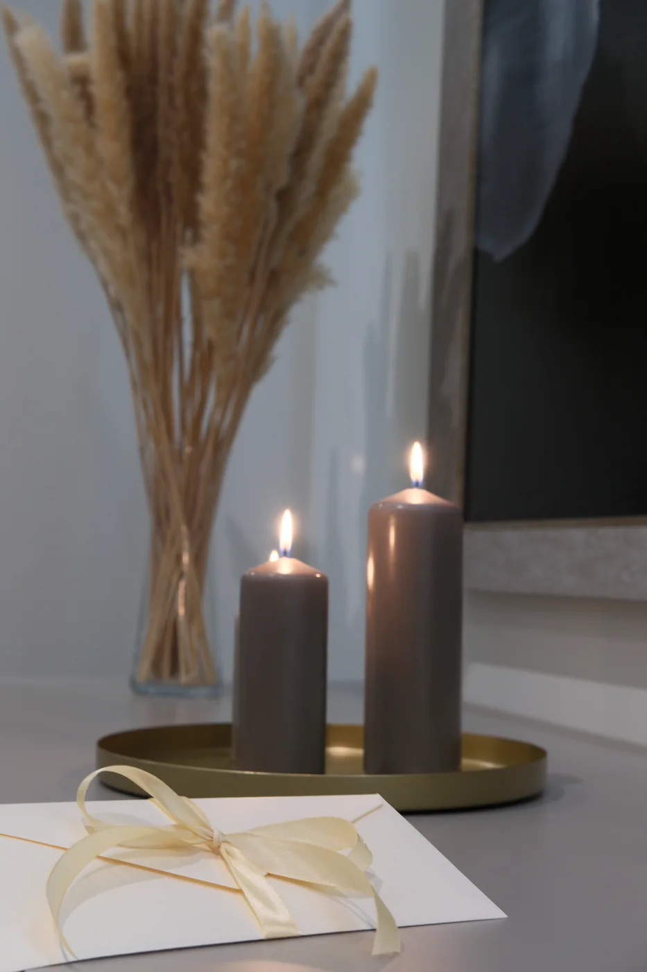 Kaspinu perrištas SPA dovanų kuponas šalia žvakių